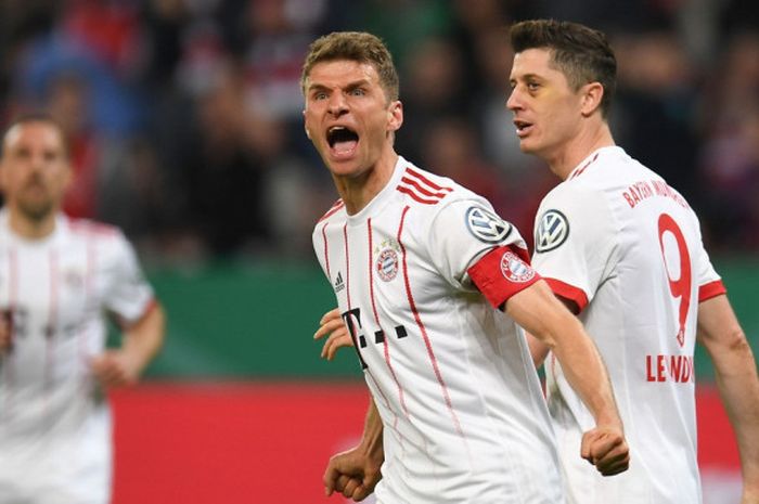  Penyerang Bayern Muenchen, Thomas Mueller (tengah), merayakan golnya ke gawang Bayer Leverkusen dalam laga semifinal Piala Jerman di Stadion BayArena, Leverkusen, Jerman pada 17 April 2018. 