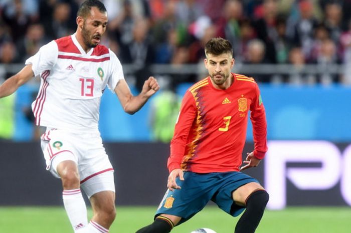 Bek timnas Spanyol, Gerard Pique (kanan), saat mengawal pergerakan pemain Maroko, Khalid Boutaib, dalam laga Grup B Piala Dunia 2018 di Stadion Kaliningrad, Kaliningrad, Rusia, pada Senin (25/6/2018).