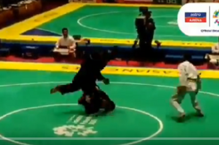 Atlet pencak silat Malaysia menendang punggung atlet pencak silat dari Singapura.