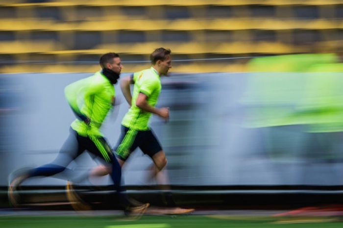 Striker Swedia, Marcus Berg (kiri), berlari bersama bek Ludwig Augustinsson dalam sesi latihan tim di Solna, Swedia, pada 6 Oktober 2017.