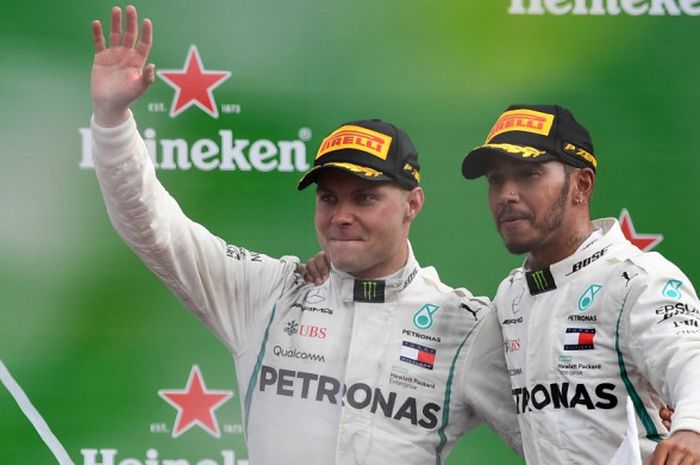 Dua pebalap Mercedes, Valtteri Bottas (kiri) dan Lewis Hamilton, melakukan selebrasi di atas podium kemenangan balapan Formula 1 (F1) GP Italia 2018 yang berlangsung di Sirkuit Monza, Italia, Minggu (2/9/2018).