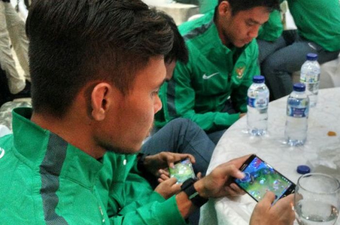 Full-back timnas U-22 Indonesia, Rezaldi Hehanusa, dan gelandang Muhammad Hargianto, saat tengah bermain gim 'Mobile Legends' setelah acara pelepasan tim di Makostrad, Jakarta, Kamis (10/8/2017).