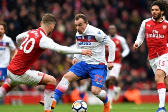 Xherdan Shaqiri berusaha melewati adangan dua pemain Arsenal pada laga lanjutan Liga Inggris di Stadion Emirates, Minggu (1/4/2018) malam WIB.