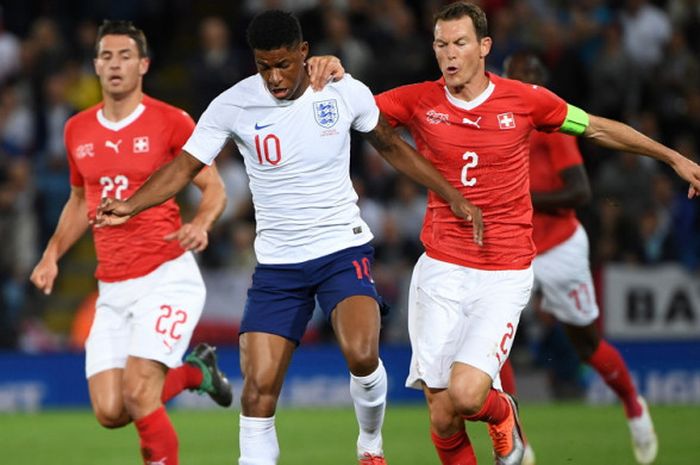 Aksi penyerang timnas Inggris, Marcus Rashford (tengah, 10), saat berduel dengan bek timnas Swiss, Stephan Lichtsteiner, dalam pertandingan uji coba yang digelar di Stadion King Power, Leicester, Inggris, pada Selasa (11/9/2018).