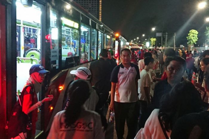 Seorang volunteer berbicara kepada tamu yang ingin naik ke shuttle bus usai Opening Ceremony Asian Games 2018 di Stadion Utama GBK, Jakarta, pada Sabtu (18/8/2018).