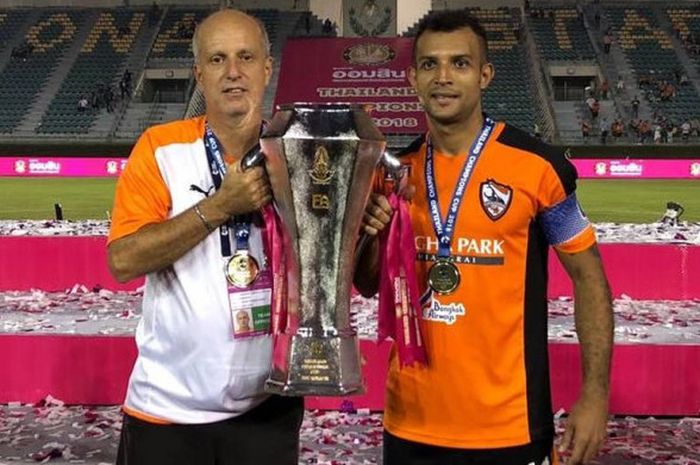 Pemain Chiangrai United, Gilberto Macena (kanan), mengangkat trofi Thailand Champions Cup 2018 bersama pelatih Chiangrai United, Alexandre Gama (kanan).