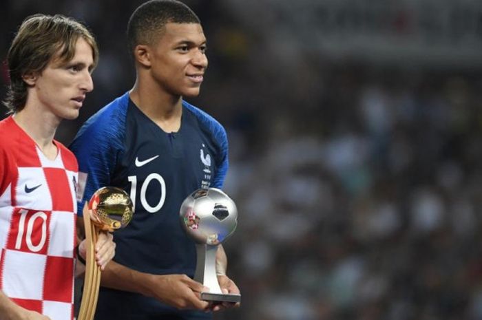 Luka Modric (kiri) dan Kylian Mbappe berpose dengan trofi Pemain Terbaik dan Pemain Muda Terbaik Piala Dunia 2018 setelah laga final antara Prancis dan Kroasia di Stadion Luzhniki, Moskow, 15 Juli 2018.