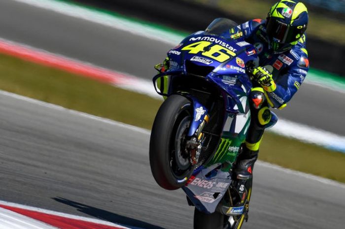    Aksi wheelie Valentino Rossi saat melintasi Sirkuit Assen dalam sesi latihan bebas MotoGP Belanda 2018 yang digelar Jumat (29/6/2018).   