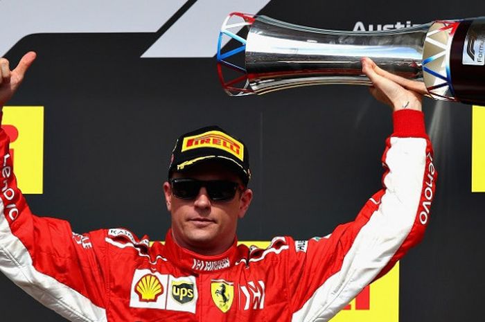 Pebalap Ferrari, Kimi Raikkonen, berpose di podium setelah finis posisi pertama pada GP Amerika Serikat 