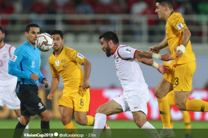 Pemain Suriah, Tamer Haj Mohammad (tengah), mendapatkan pengawalan dari gelandang Australia, Tom Rogic, pada pertandingan matchday ketiga Grup B PIala Asia 2019 di Stadion Khalifa bin Zayed, Uni Emirat Arab, Selasa (15/1/2019).