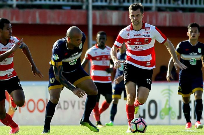 Cameron Watson (Madura United/kanan) sedang berduel melawan Ivan Carlos (Persela Lamongan) di Stadion Gelora Pamelinggan (04/08/2017) Jumat.