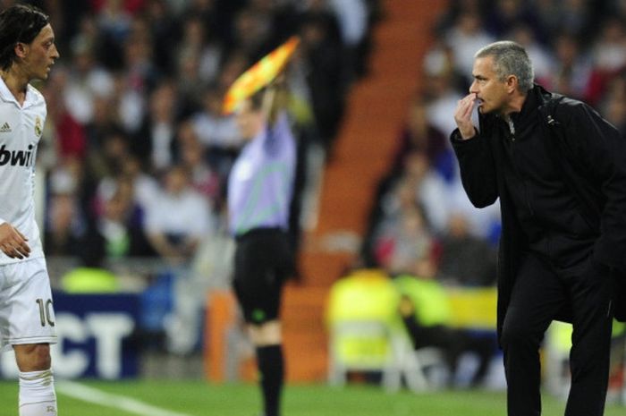 Jose Mourinho (kanan) berbicara kepada Mesut Oezil di lapangan dalam pertandingan Liga Champions antara Real Madrid lawan Bayern Muenchen di Santiago Bernabeu, Madrid, 25 April 2012.