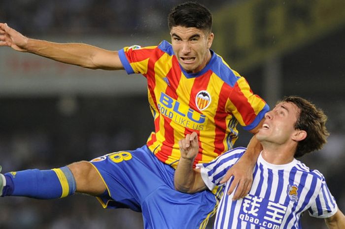 Gelandang Valencia, Carlos Soler (kiri), berduel dengan pemain Real Sociedad, Alvaro Odriozola, dalam pertandingan La Liga 2017-2018 di Stadion Anoeta, San Sebastian, Spanyol, pada 24 September 2017.