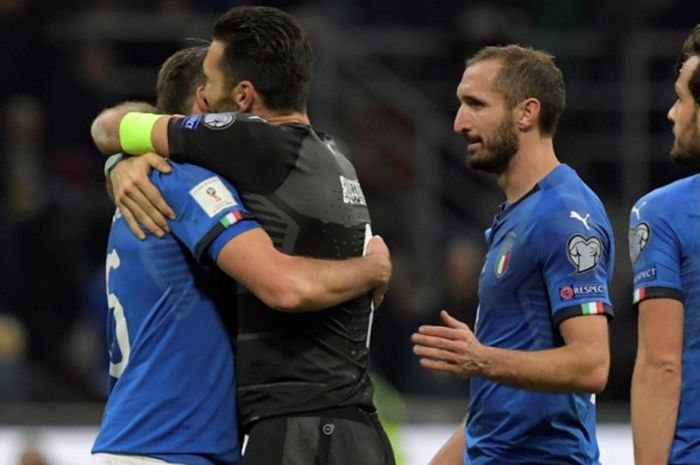 Gianluigi Buffon (kedua dari kiri) memeluk Andrea Barzagli setelah timnas Italia bermain imbang 0-0 dengan Swedia pada partai kedua play-off Kualifikasi Piala Dunia 2018 di Stadion Giuseppe MEazza, Selasa (14/11/2017) dini hari WIB.