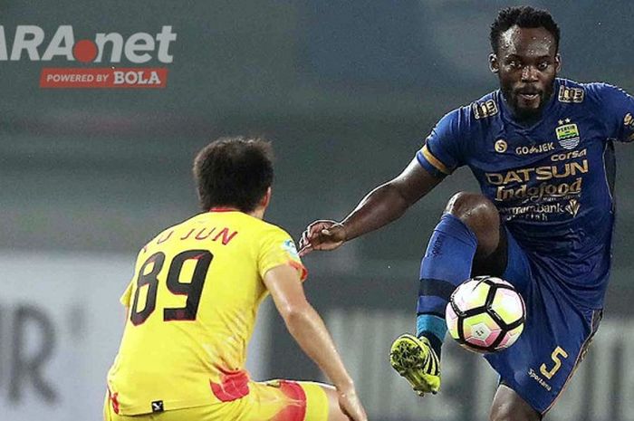 Gelandang Persib Bandung, Michael Essien (kanan), mengontrol bola dibayangi gelandang Bhayangkara FC, Lee Yoo-joon, dalam laga lanjutan Liga 1 di Stadion Patriot Chandrabhaga, Bekasi, Minggu (4/6/2017).