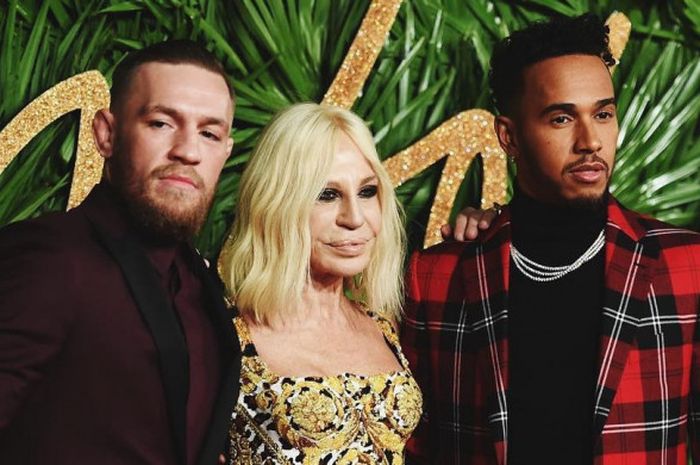 Donatella Versace berada diantara Conor McGregor (kiri) dan Lewis Hamilton