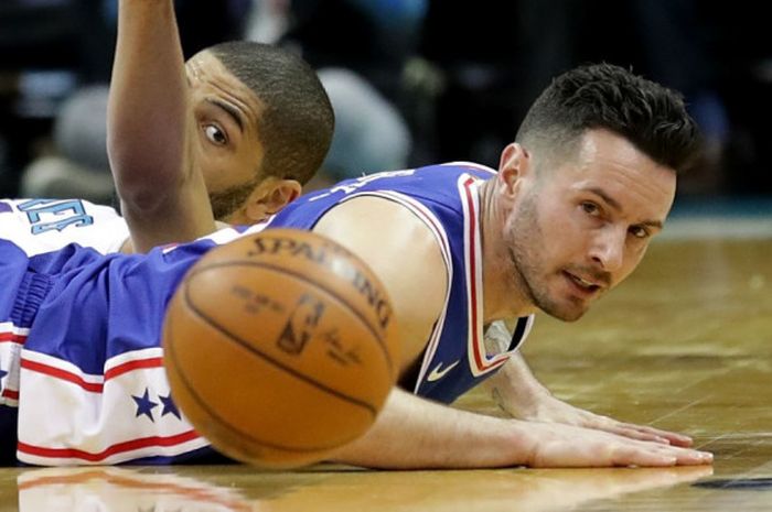 Shooting guard Philadelphia 76ers, JJ Redick (jersey biru), terjatuh saat berebut bola dengan pemain Charlotte Hornets, Nicolas Batum, pada laga musim reguler NBA 2017-2018 di Spectrum Center, Charlotte, North Carolina, Amerika Serikat, 6 Maret 2018.