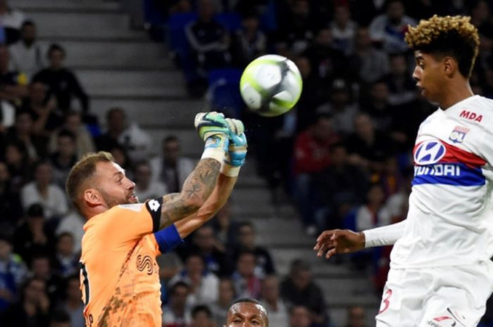 Pemain Olympique Lyon, Willem Geubbels (kanan), berduel dengan kiper Dijon, Baptiste Reynet, dalam laga Liga Prancis di Stadion Groupama, Decines-Charpieu, pada 23 September 2017.