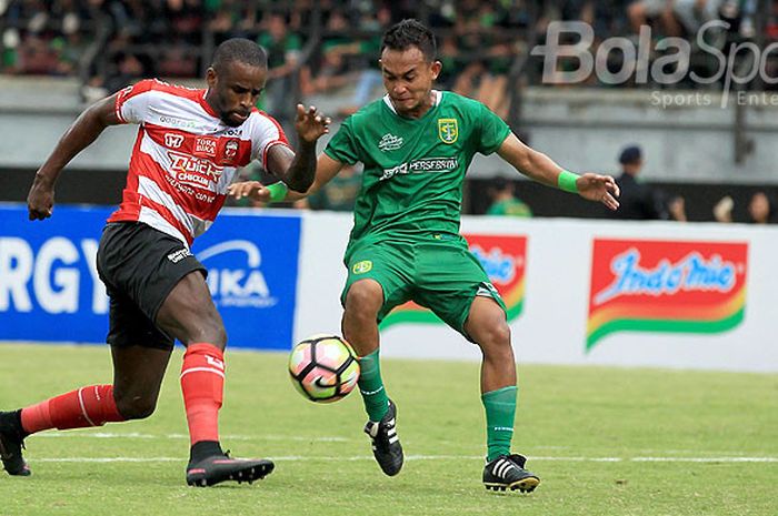 Striker Madura United, Greg Nwokolo (kiri), mendapat pengawalan ketat bek Persebaya Surabaya, Abu Rizal Maulana, pada laga Piala Presiden Grup C di Gelora Bung Tomo Surabaya., Minggu (28/1/2018).