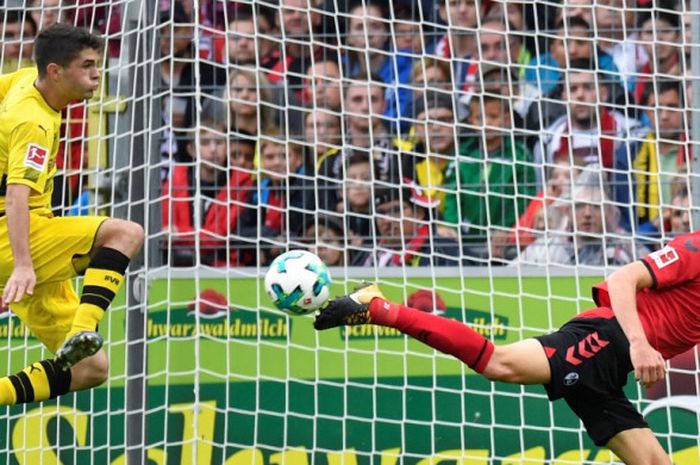 Gelandang Freiburg, Amir Abrashi (kanan), menahan tembakan pemain Borussia Dortmund, Christian Pulisic, dalam laga Liga Jerman di Stadion Schwarzwald, Freiburg, pada 9 September 2017.