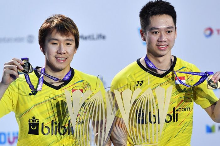 Pasangan ganda putra Indonesia, Marcus Fernaldi Gideon (kanan)/Kevin Sanjaya Sukamuljo, berpose dengan trofi dan medali yang mereka raih seusai menjuarai turnamen BWF Superseries Finals 2017 di Hamdan Sports Complex, Dubai, Uni Emirat Arab, Minggu (17/12/2017).