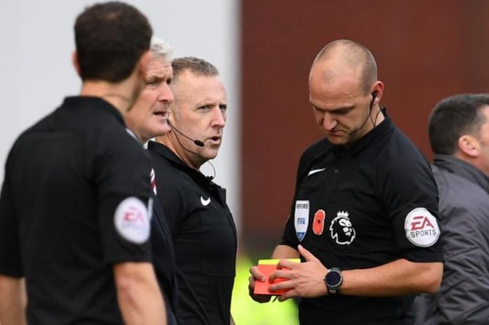 Wasit Robert Madley (kanan) berbicara dengan Jonathan Moss (tengah) selaku wasit keempat pada laga Liga Inggris antara Stoke City lawan Leicester City di Bet365 Stadium, Stoke on Trent, 4 November 2017.