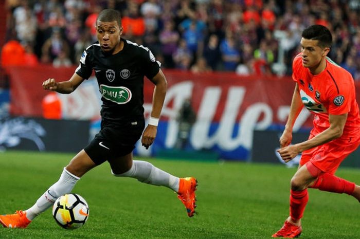 Penyerang Paris Saint-Germain, Kylian Mbappe (kiri), mengecoh gelandang Caen, Stef Peeters, dalam laga semifinal Piala Prancis di Stadion Michel d'Ornano, Caen pada 18 April 2018.