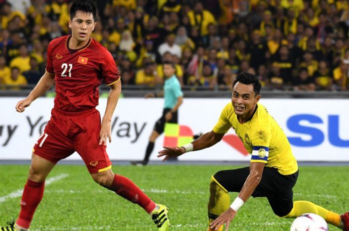 Kapten timnas Malaysia, Zaquan Adha nyaris terjatuh seusai duel dengan bek timnas Vietnam, Tran Dinh Trong pada final pertama Piala AFF 2018 di Stadion Nasional Bukit Jalil, Kuala Lumpur, 11 Desember 2018. 