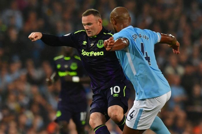 Striker Everton, Wayne Rooney (kiri), berduel dengan bek Manchester City, Vincent Kompany, dalam laga Liga Inggris di Stadion Etihad, Manchester, pada 21 Agustus 2017.