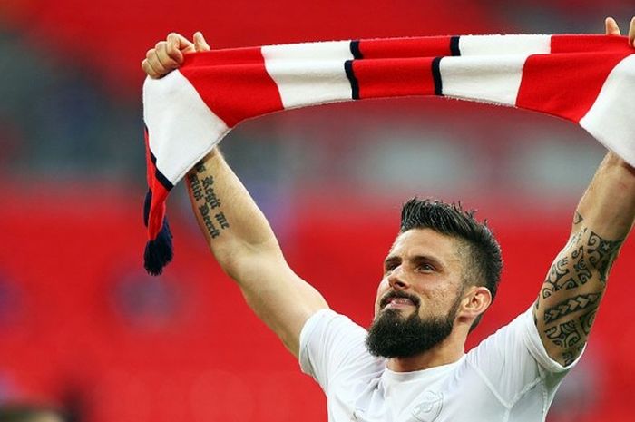 Penyerang Arsenal, Olivier Giroud, melakukan selebrasi dengan mengangkat trofi usai mengalahkan Chelsea dalam laga final Piala FA 2016-2017 di Stadion Wembley, London, (27/5/2017).