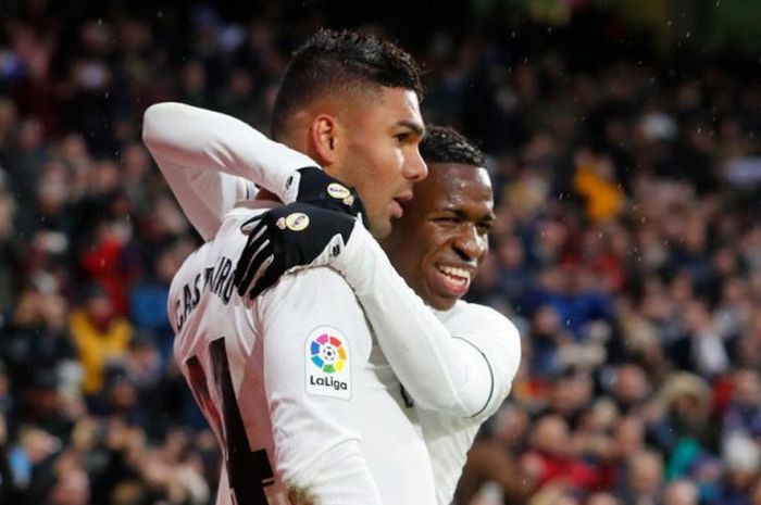 Striker muda Brasil, Vinicius Junior, memeluk Casemiro yang mencetak gol untuk Real Madrid saat berhadapan melawan Sevilla dalam ajang Liga Spanyol pada Sabtu (19/1/2019) di Stadion Santiago Bernabeu, Madrid.