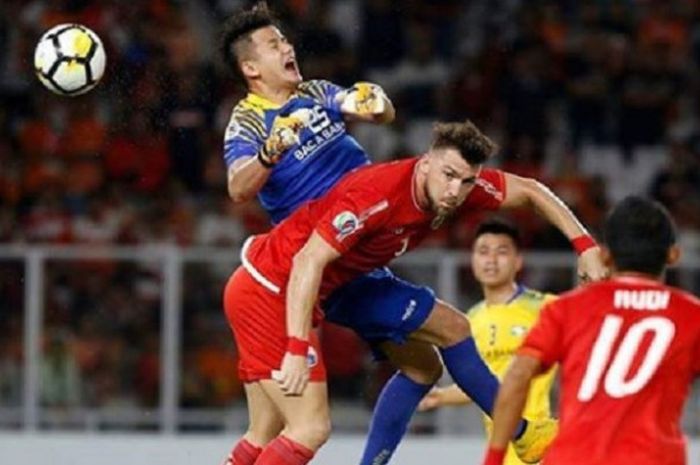 Striker Persija Jakarta Marko Simic (depan) berebut bola dengan kiper Song Lam Nghe An Le Quang Dai dalam duel penyisihan Grup H Piala AFC 2018, Rabu (14/3/2018) malam WIB.