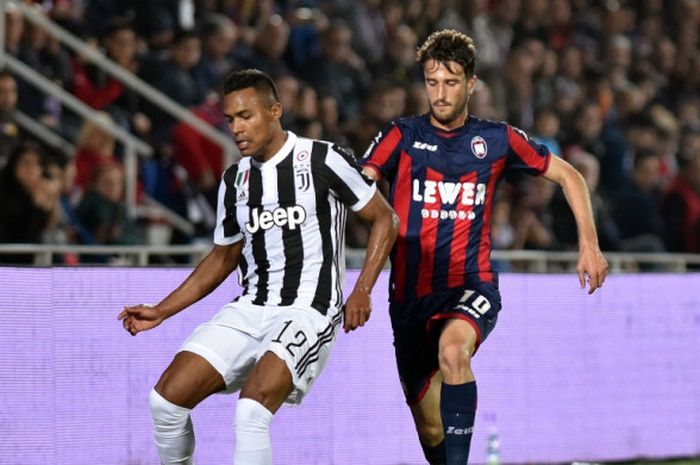 Bek Juventus, Alex Sandro (kiri), berduel dengan pemain Crotone, Andrea Barberis, dalam laga Liga Italia di Stadion Ezio Scida, Crotone pada 18 April 2018.