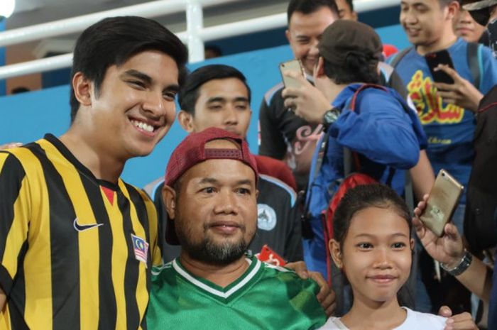 Menteri Belia dan Sukan (Menpora) Malaysia, Syed Saddiq Abdul Rahman, melayani permintaan foto bersama dengan suporter di Stadion Gelora Delta Sidoarjo, Sabtu (14/7/2018).