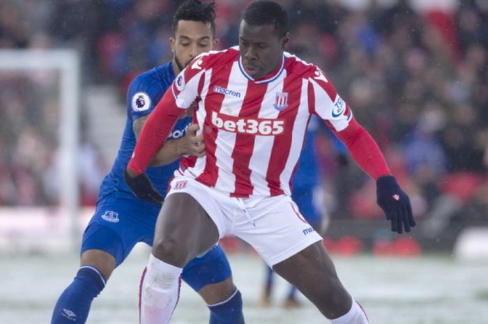 Striker Everton Theo Walcott (belakang) berebut bola dengan bek Stoke City, Kurt Zouma, dalam partai Liga Inggris di Bet 365 Stadium, Stoke on Trent, 17 Maret 2018.