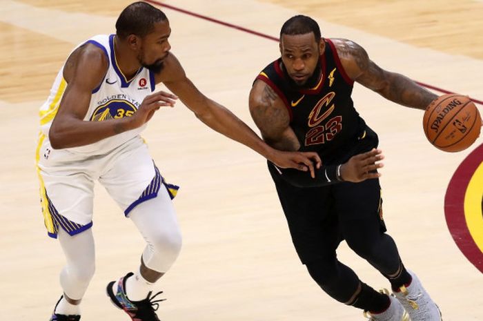 Pebasket megabintang Cleveland Cavaliers, LeBron James (jersey hitam), berupaya melewati penjagaan pemain Golden State Warriors, Kevin Durant, pada laga gim ketiga seri final NBA 2018 di Quicken Loans Arena, Cleveland, Ohio, Amerika Serikat, Kamis (7/6/2018).