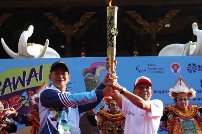 Ketua Umum Inapgoc Raja Sapta Oktohari (kiri) memegang obor yang digunakan pada pawai obor jelang Asian Para Games 2018 di Bali, Minggu (16/9/2018).