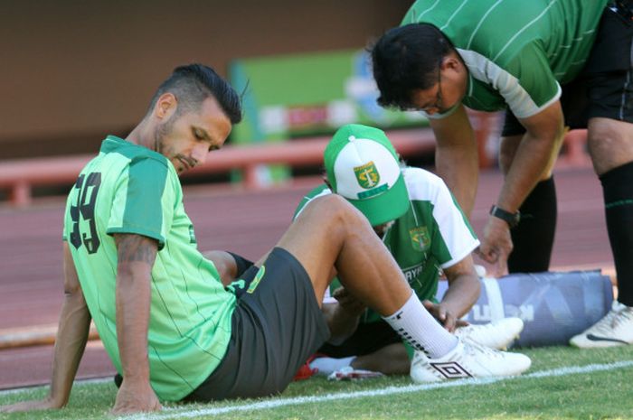 Gelandang Persebaya, Raphael Maitimo, saat menjalani perawatan oleh fisioterapis pada sesi latihan tim di Stadion Jenggolo, Sidoarjo, Kamis (2/8/2018).