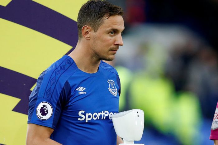 Phil Jagielka, kapten Everton sedang membawa robot yang digunakan menjadi maskot pertandingan antara Everton dan Newcastle United, Selasa (24/4/2018)