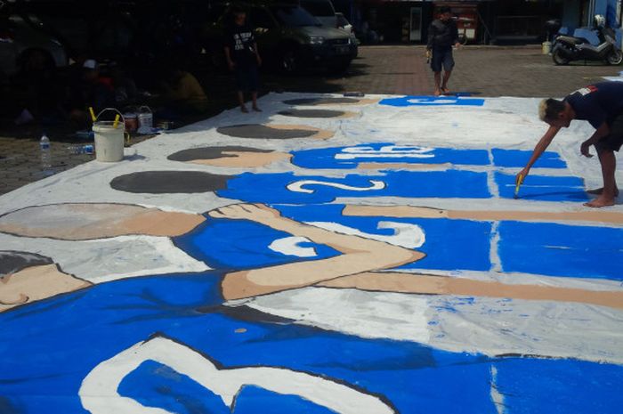 Salah seorang Bobotoh sedang membuat gambar pemain di atas kain putih berukuran besar ‎di lapangan parkir Stadion Persib, Jalan Ahmad Yani, Kota Bandung, Sabtu (11/11/2017). 