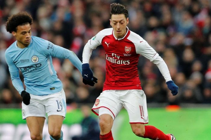 Gelandang Arsenal, Mesut Oezil (kanan), berduel dengan pemain Manchester City, Leroy Sane, dalam laga final Piala Liga Inggris di Stadion Wembley, London, pada 25 Februari 2018.