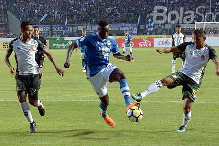  Striker Persib Bandung, Ezechiel N'Douassel (tengah), mendapat pengawalan ketat dari dua pemain PS Tira dalam laga perdana Liga 1 2018 di di Stadion Gelora Bandung Lautan Api, Senin (26/3/2018).  