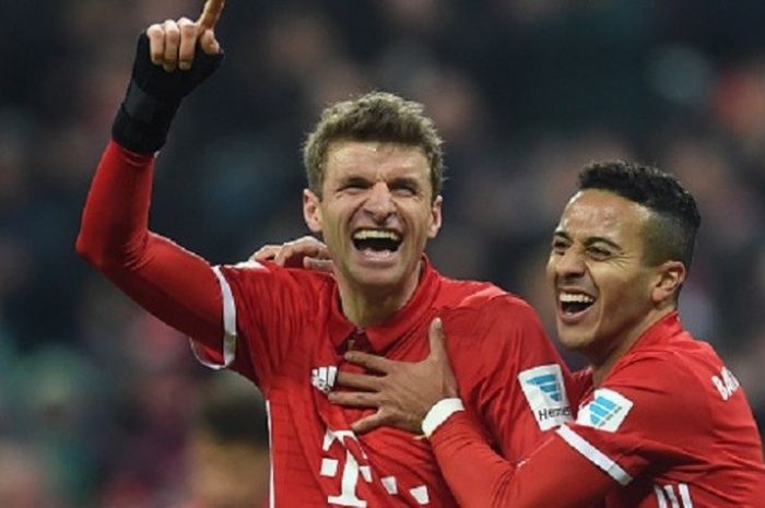 Thomas Mueller merayakan gol pertamanya musim ini bersama Thiago Alcantara saat Bayern Muenchen menang atas Wolfsburg di Allianz Arena, Sabtu (10/12/2016).