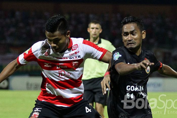 Pemain Madura United, Asep Berlian (kiri), sedang berduel dengan pemain Persija Jakarta, Ramdani Lestaluhu, dalam pertandingan Liga 1.