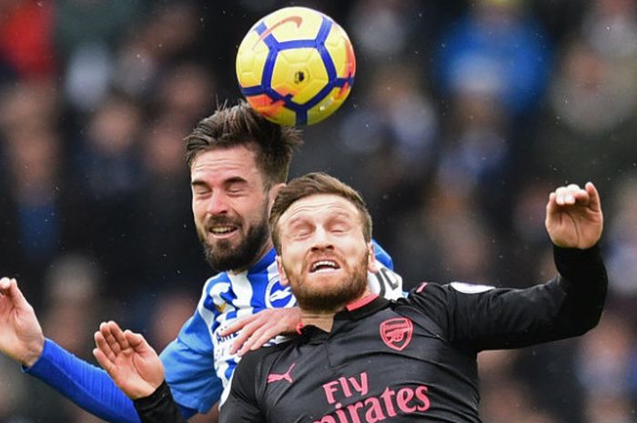 Bek Arsenal, Shkodran Mustafi, berduel dengan pemain Brighton & Hove Albion dalam partai Liga Inggris di The American Express Community Stadium, Minggu (4/3/2018)