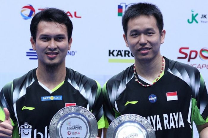 Pasangan ganda putra Indonesia, Mohammad Ahsan/Hendra Setiawan, berpose setelah menjadi juara Singapore Open 2018 di Singapore Indoor Stadium, Minggu (22/7/2018).