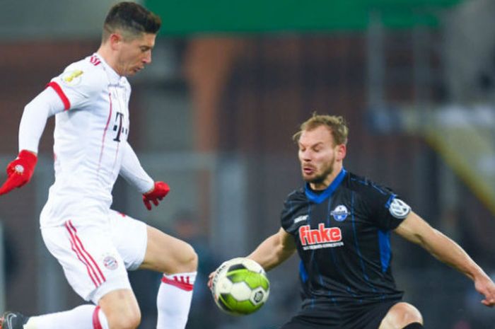 Penyerang FC Bayern Muenchen, Robert Lewandowski (baju putih), berebut bola dengan pemain SC Paderborn, Christian Strohdiek pada pertandingan perempat final di Stadion Benteler-Arena, Paderborn, Jerman, Rabu (7/2/2018) dini hari WIB. 