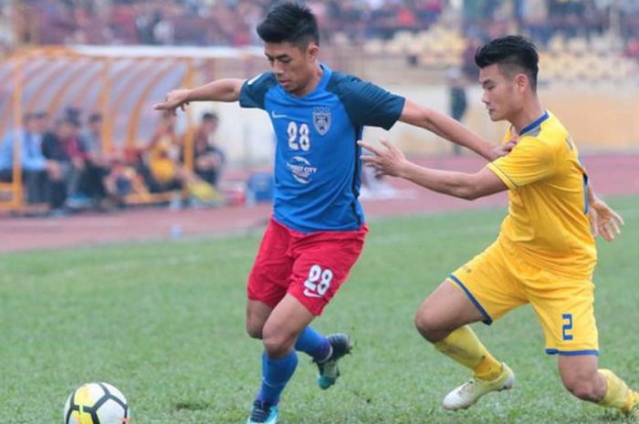 Aksi penyerang Johor Darul Takzim, Syafiq Ahmad (kiri) diganggu bek Song Lam Nghe An, Pham The Nhat 