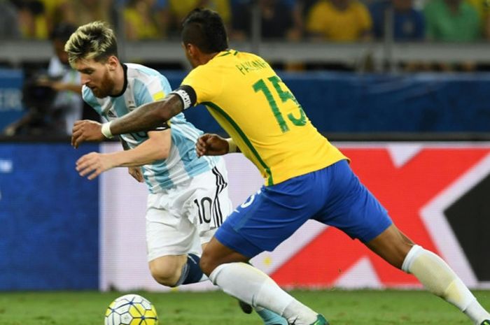  Megabintang Argentina, Lionel Messi (kiri), berduel dengan gelandang Brasil, Paulinho, dalam laga Kualifikasi Piala Dunia 2018 Zona Amerika Selatan di Belo Horizonte, Brasil, pada 10 November 2016. 