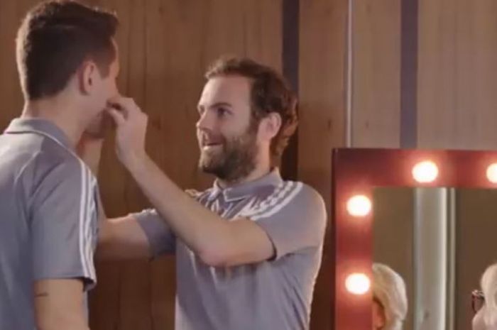 Pemain Manchester United, Juan Mata (kanan), memasangkan kumis palsu di wajah Ander Herrera.